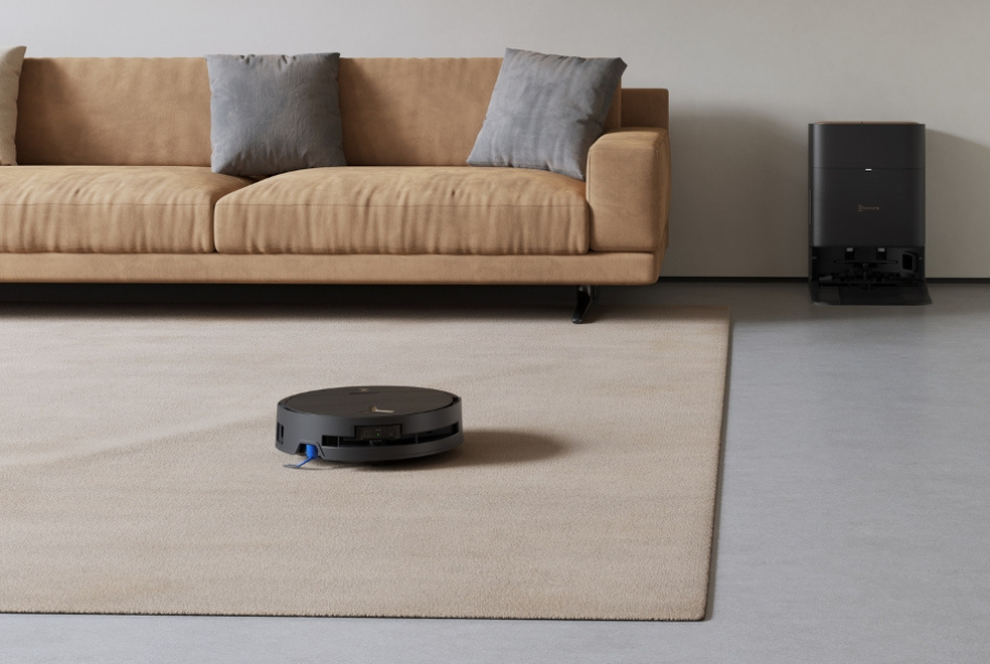 a deebot robot vacuum quietly cleans the living room in dim lighting