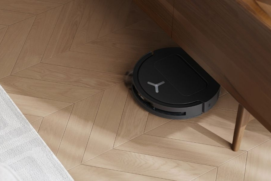 deebot robot vacuum cleaning underneath a cabinet