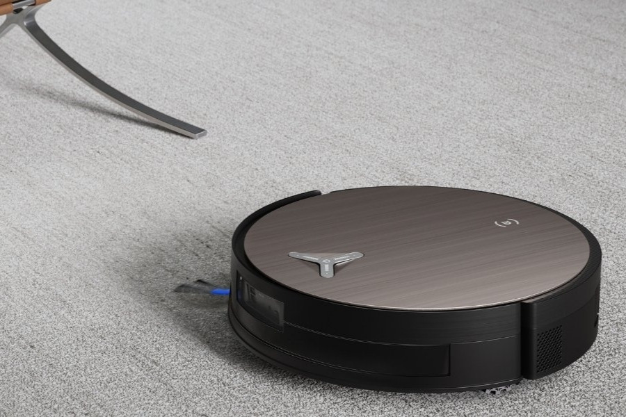 deebot robot vacuum cleaning wool rug near a chair