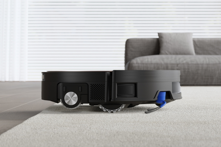 a closeup of deebot robot vacuum cleaning wool rug