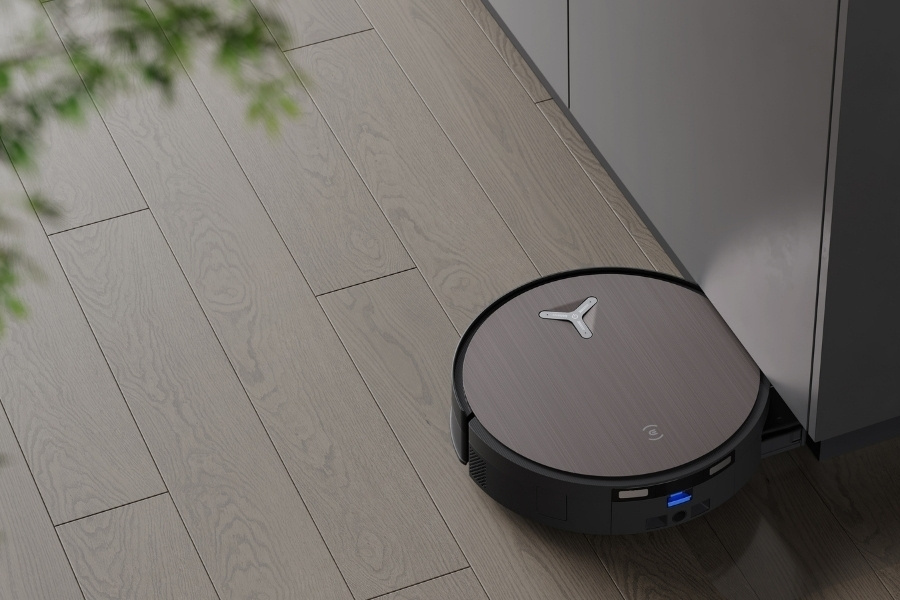 deebot robot vacuum cleaning pine needles underneath the cabinet
