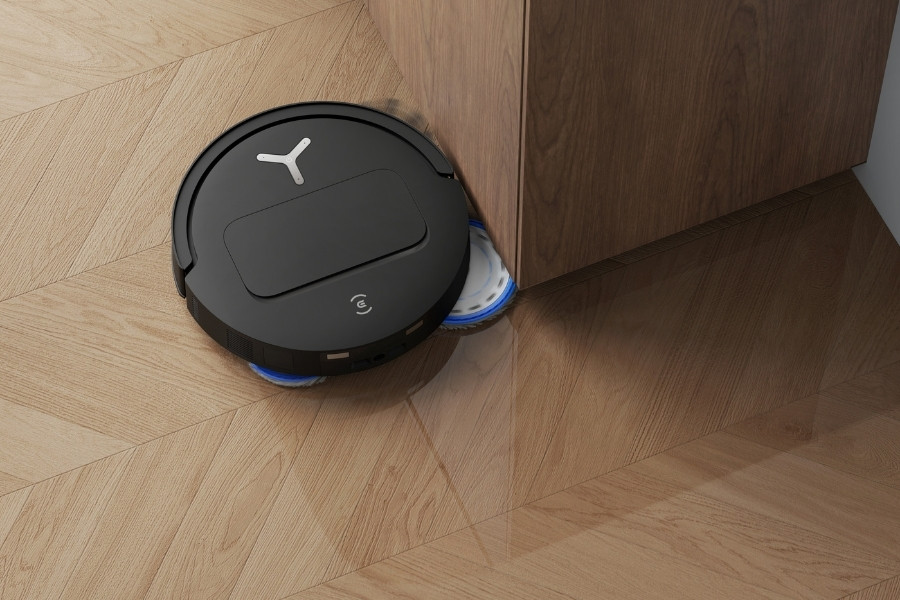deebot robot vacuum and mop cleaning a cabinet corner