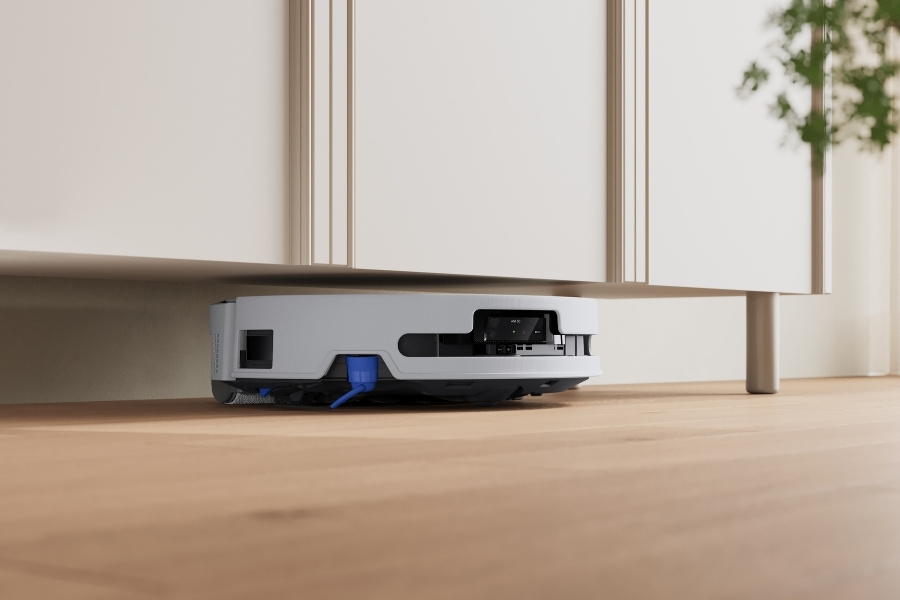 deebot robot vacuum cleaning under a cabinet