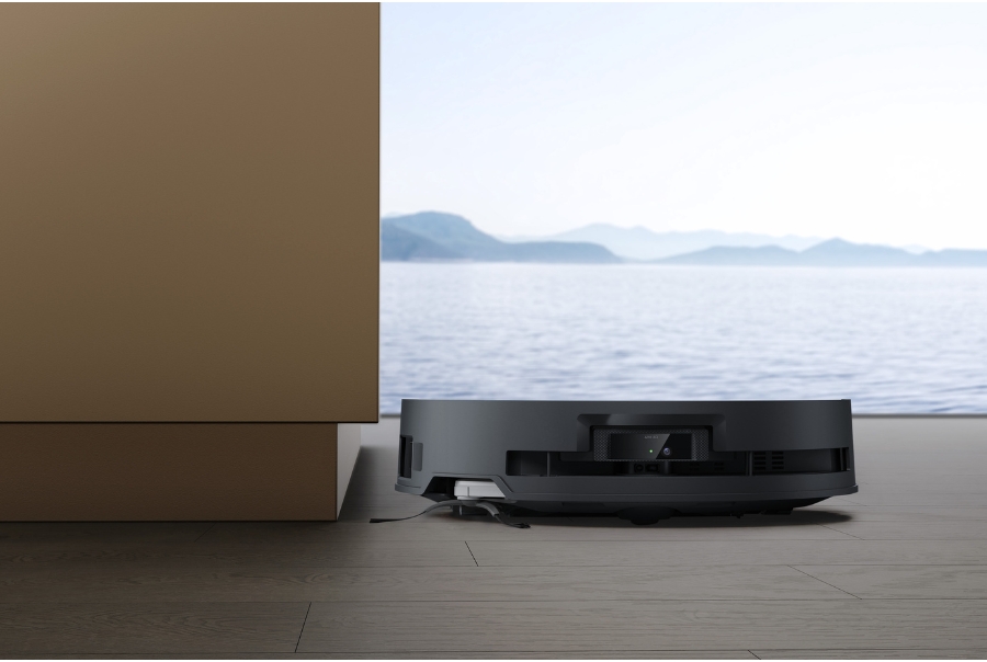 deebot robot vacuum cleaner cleaning near a cabinet