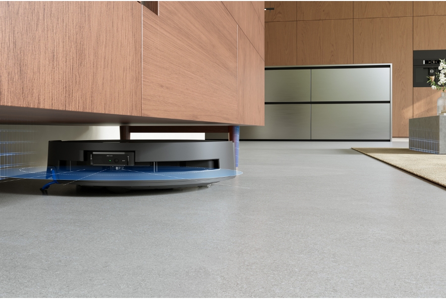aspirateur robot Deebot glissant sous un meuble en bois