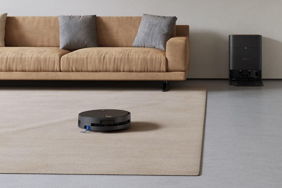 Aspirateur robot deebot en train de nettoyer calmement un tapis