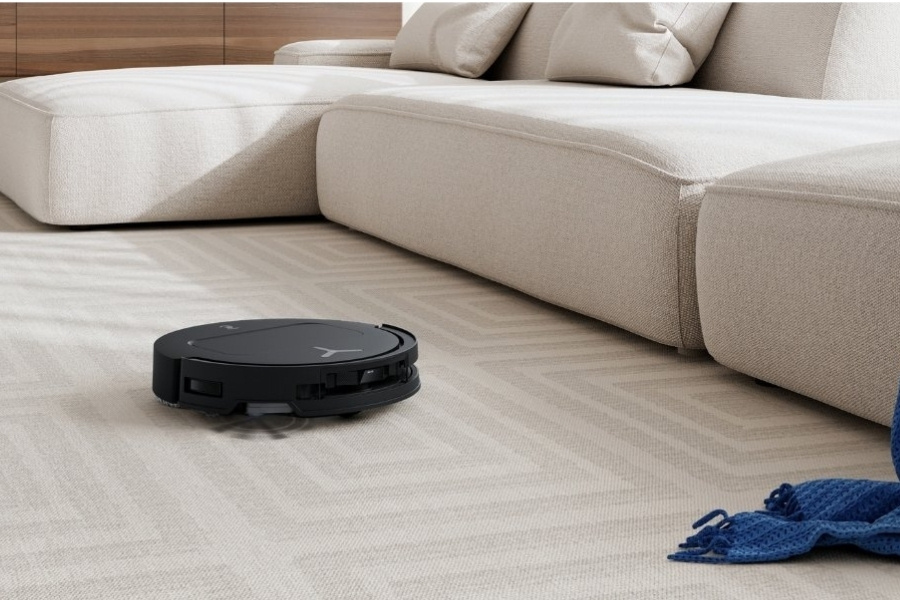 aspirateur robot deebot qui aspire de la poussiere sur un tapis