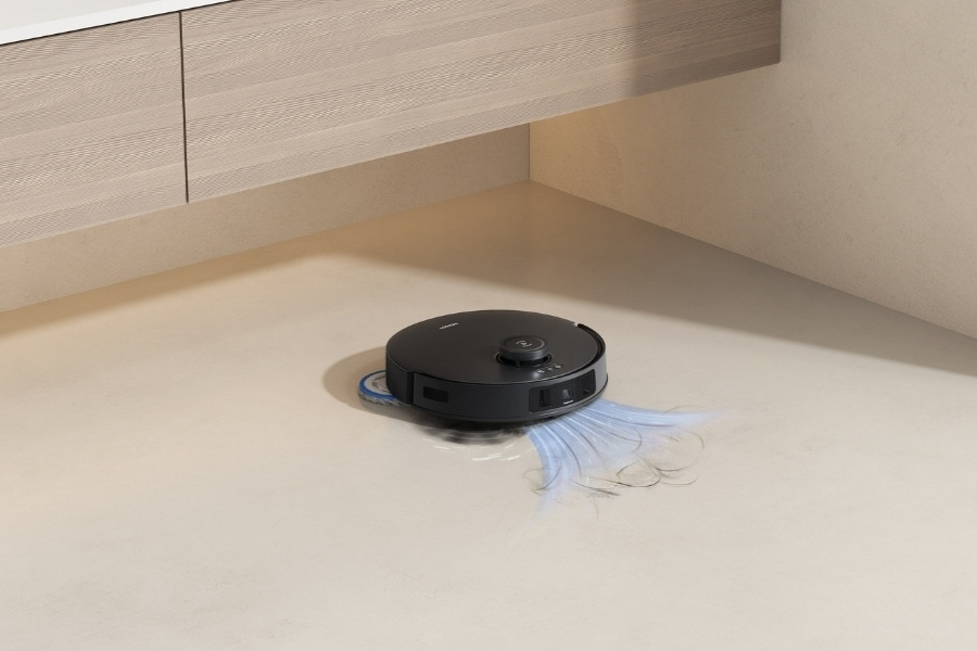 aspirateur robot deebot qui aspire des cheveux sur un carrelage