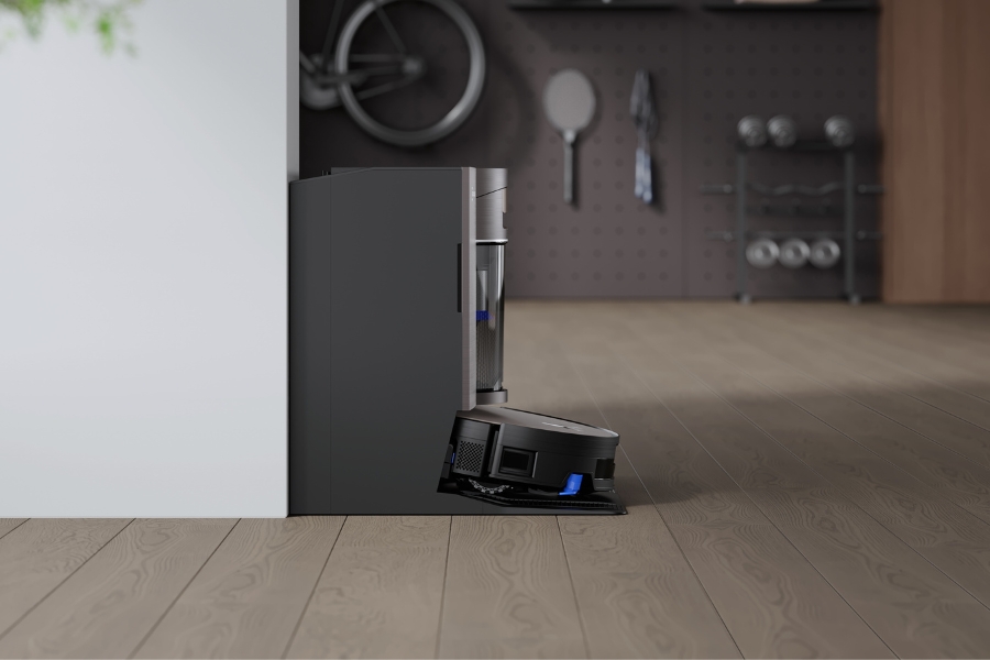 aspirateur robot deebot qui charge dans sa station sur un sol en pvc