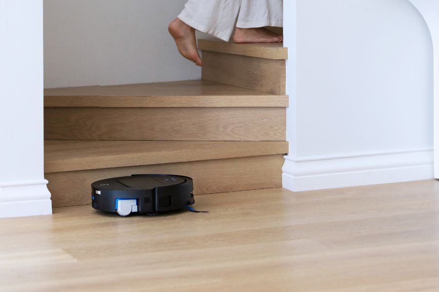 aspirateur robot deebot qui nettoie pres des escaliers