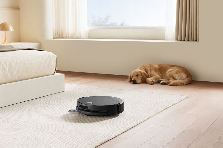 aspirateur robot deebot nettoyant un tapis a cote chien endormi