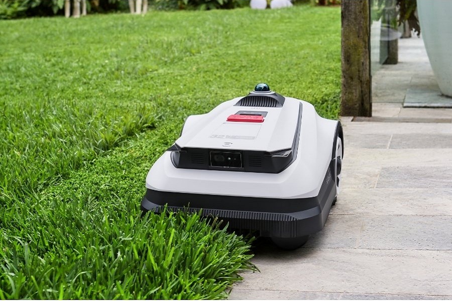 goat robot lawn mower trimming the edge between grass and tile