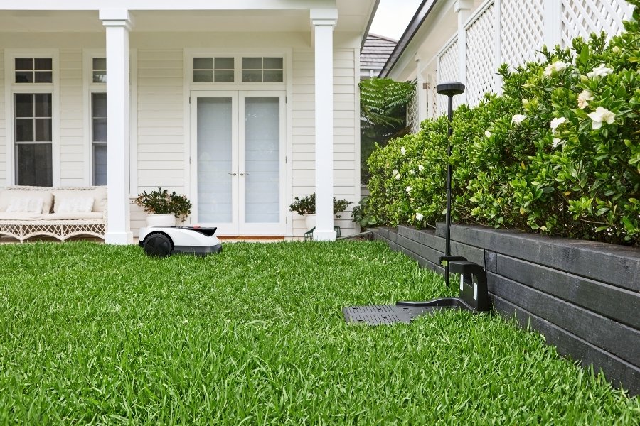 goat robot lawn mower and rtk reference station in a garden