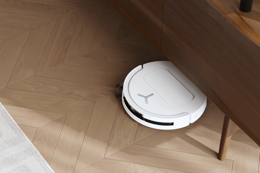 deebot robot vacuum cleaning underneath a cabinet