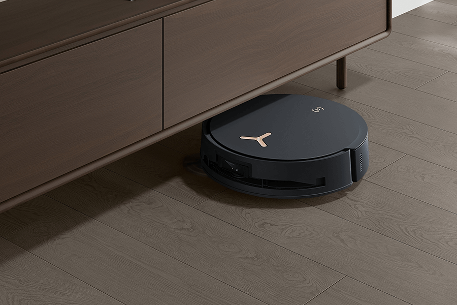 deebot robot vacuum cleaning pine needles underneath the cabinet