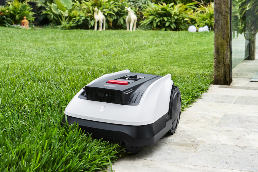 goat robot mower cutting tall grass on the edge