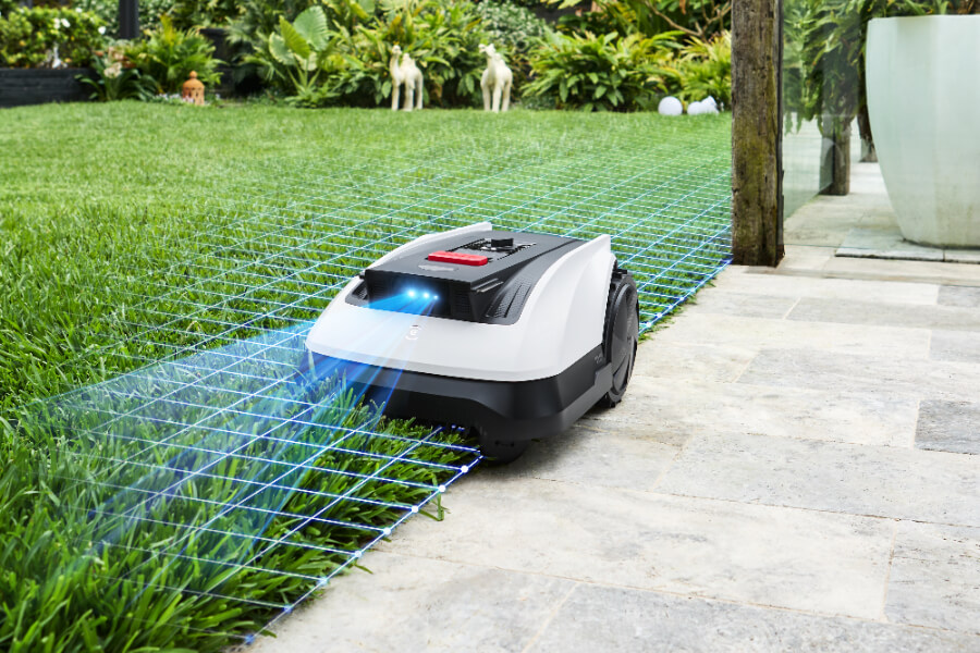 goat robot lawn mower navigating the edge of a yard