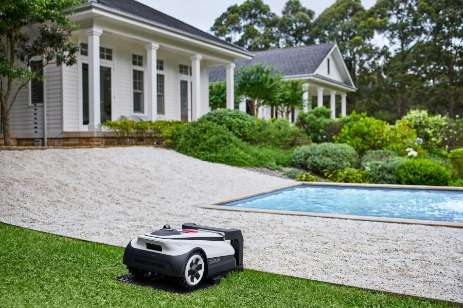 goat robot lawn mower mowing near pool