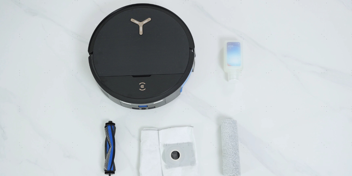 a floor robot with a roller brush, mop pads, side brush, and cleaning solution placed nearby.
