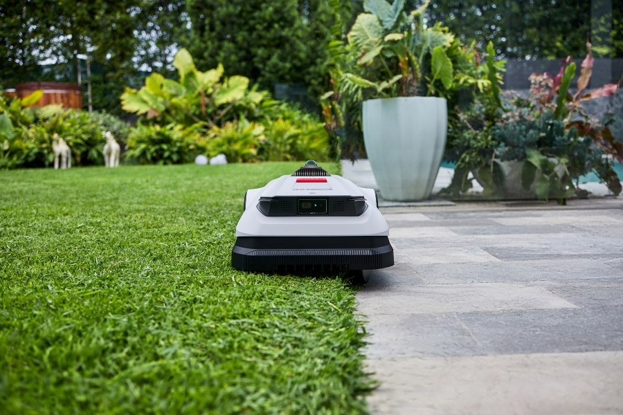 goat robot mower trimming grass on the edge