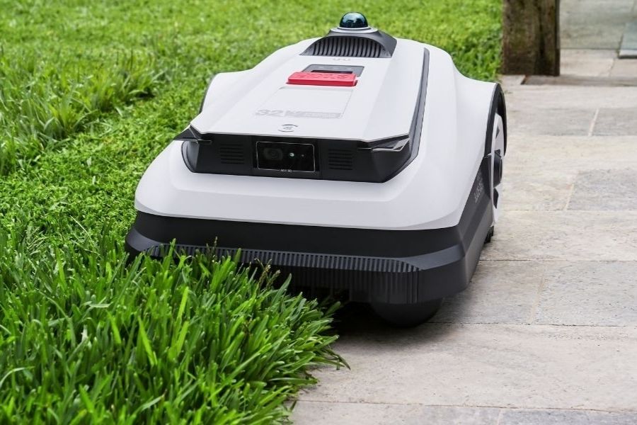 goat robot mower cutting tall grass on the edge